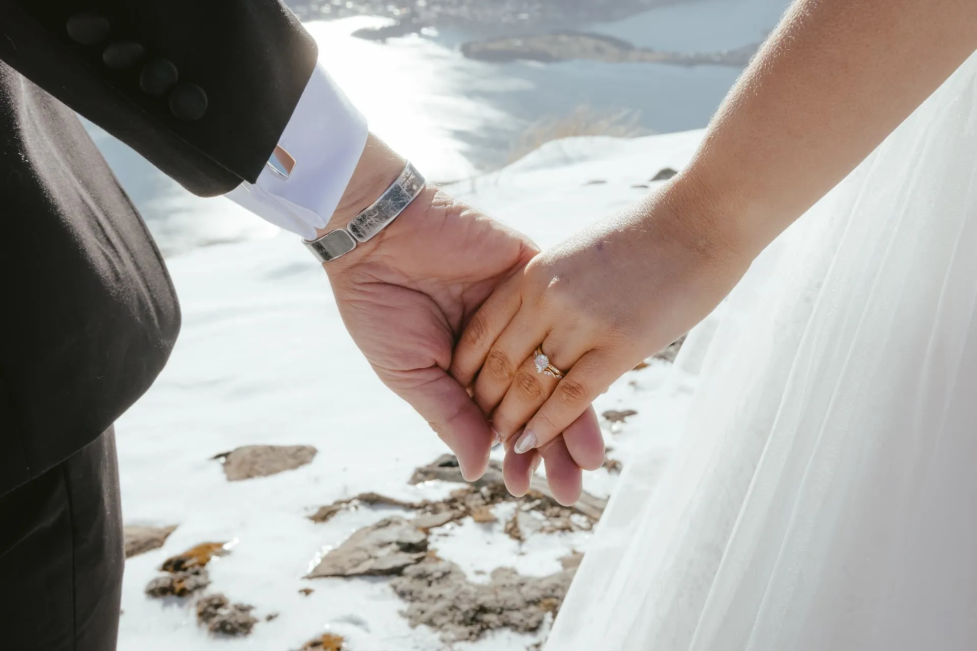 Close-up of the couple\u2019s hands and wedding ring on a winter elopement at Cecil Peak.