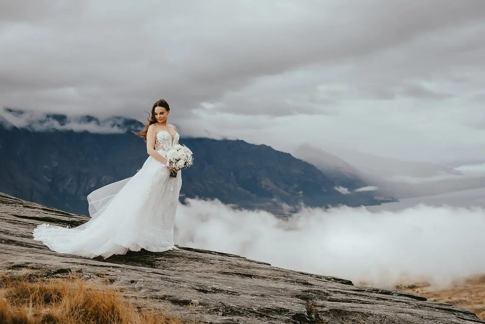 Bride on a rock ledge with mist over the mountains at Deer Park Heights