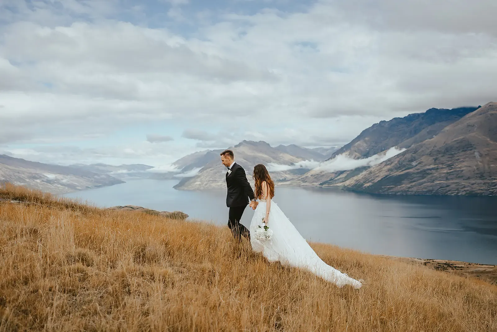 Couple walking with Lake Whakatipu below at Deer Park Heights