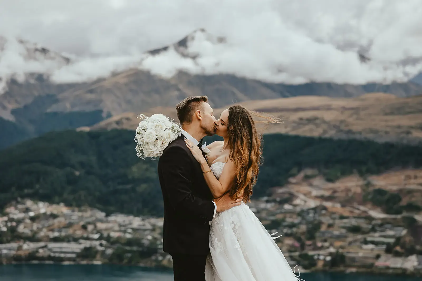 Couple kissing above Queenstown at Deer Park Heights