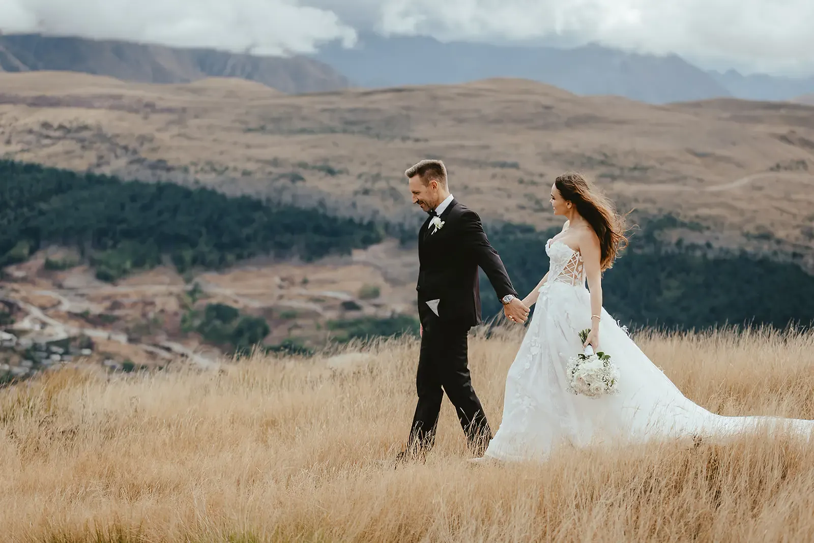 Couple walking through golden tussock at Deer Park Heights