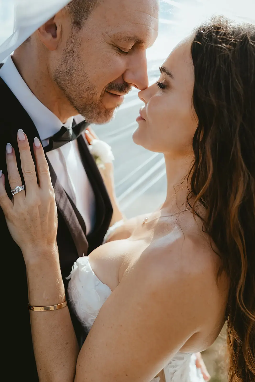 Couple nose to nose under the veil, ring in view, at Deer Park Heights