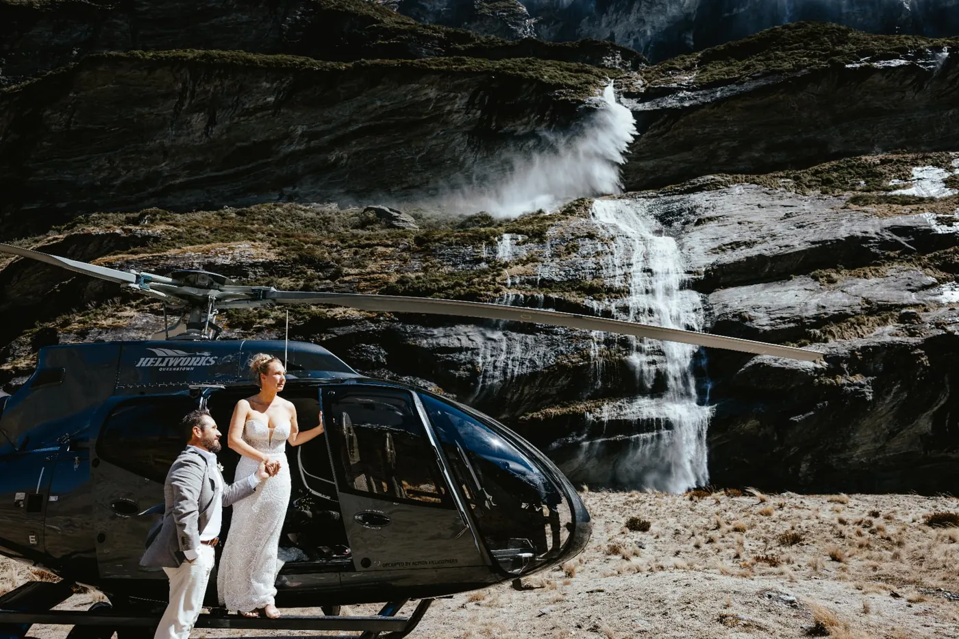 Bride stepping out of the helicopter at Earnslaw Burn for her heli elopement.
