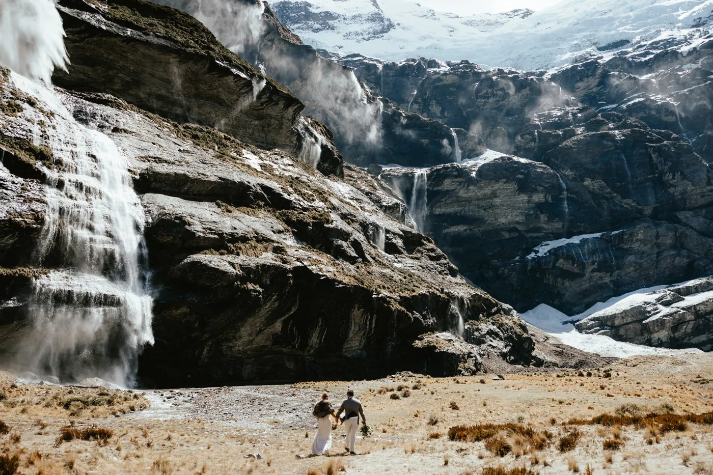 Heli elopement couple dwarfed by the glacier cliffs of Earnslaw Burn, north of Queenstown.