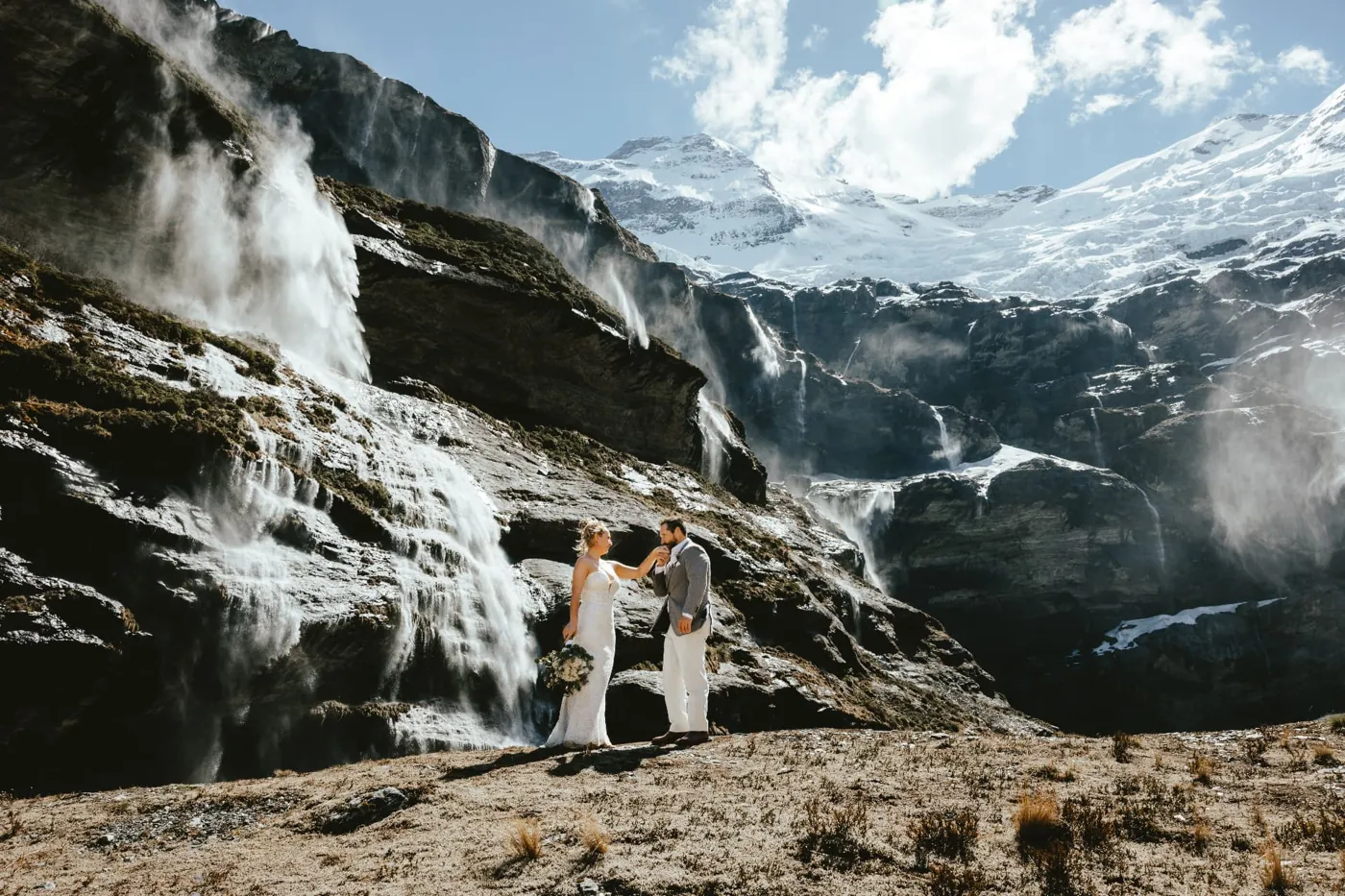 Heli wedding couple holding hands in the Earnslaw Burn glacier basin above Glenorchy.