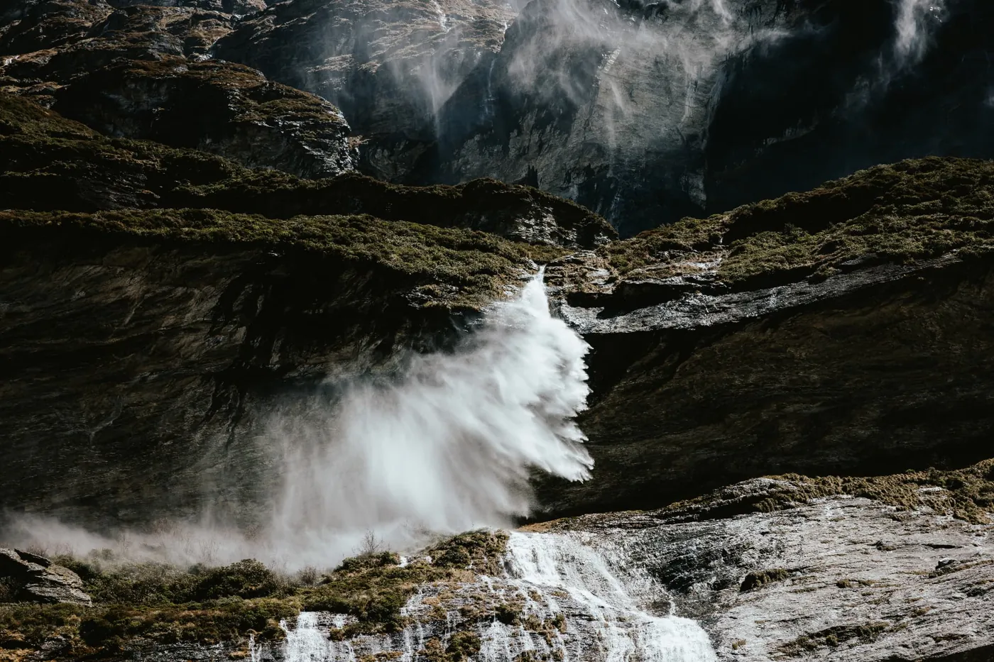 Glacier meltwater blowing off an Earnslaw Burn waterfall in the wind, New Zealand.