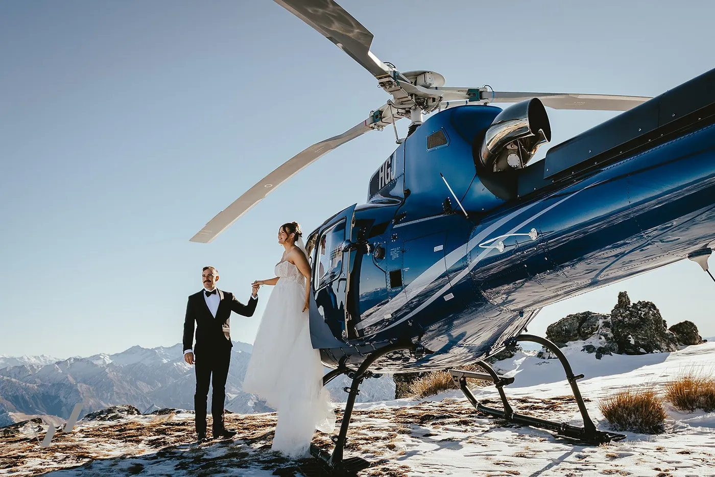 Bride and groom toasting champagne on a clifftop above the lake