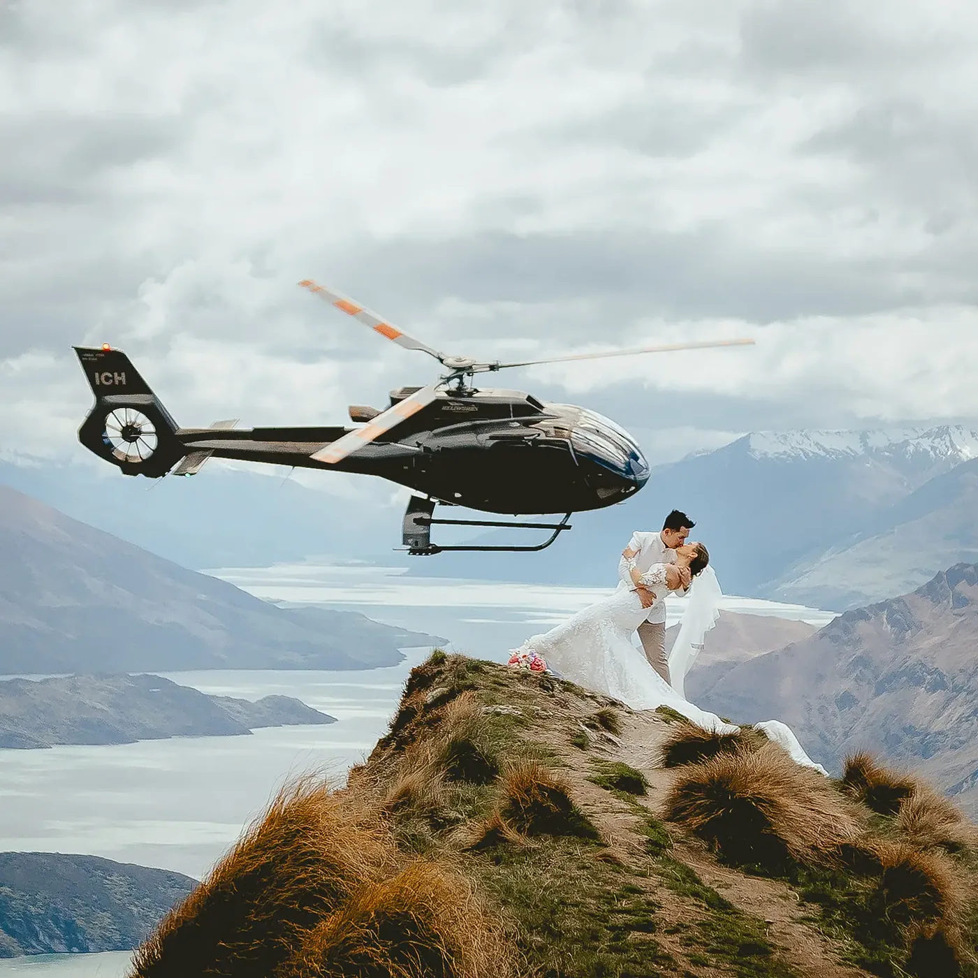 A couple in a dip kiss on Coromandel Peak above Lake Wānaka.