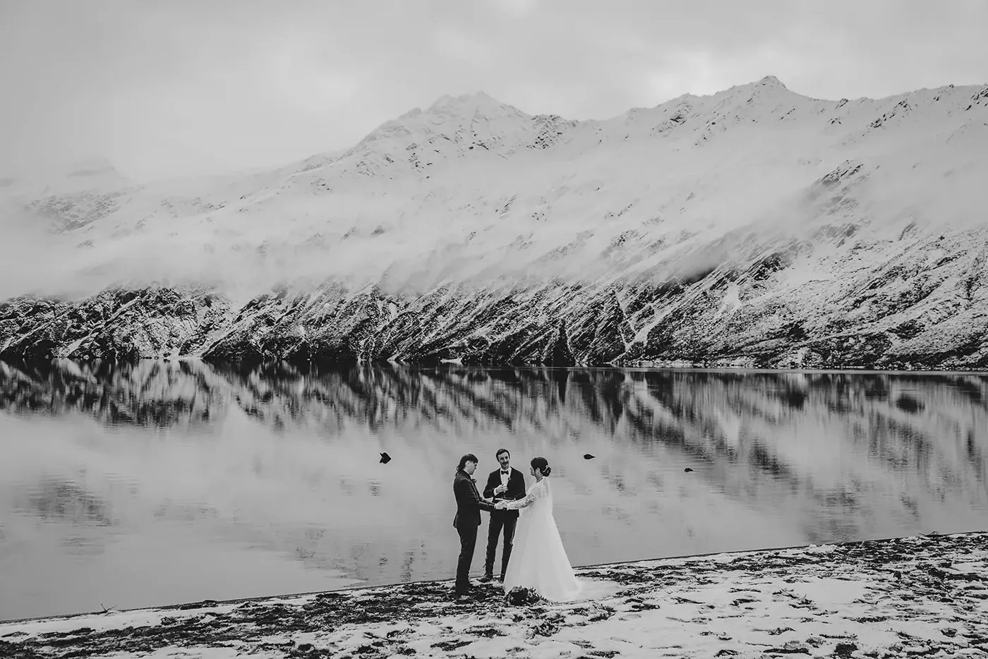 Black and white photo of wedding vows at Lake Lochnagar under low cloud and snowy peaks