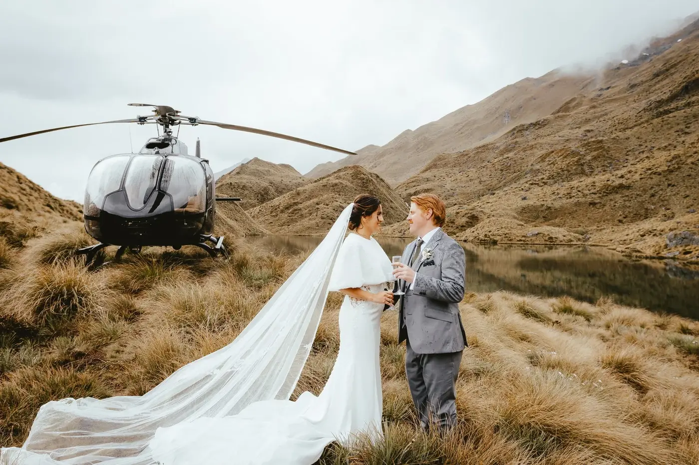 A couple walking together beside a glacial river valley near Wānaka.