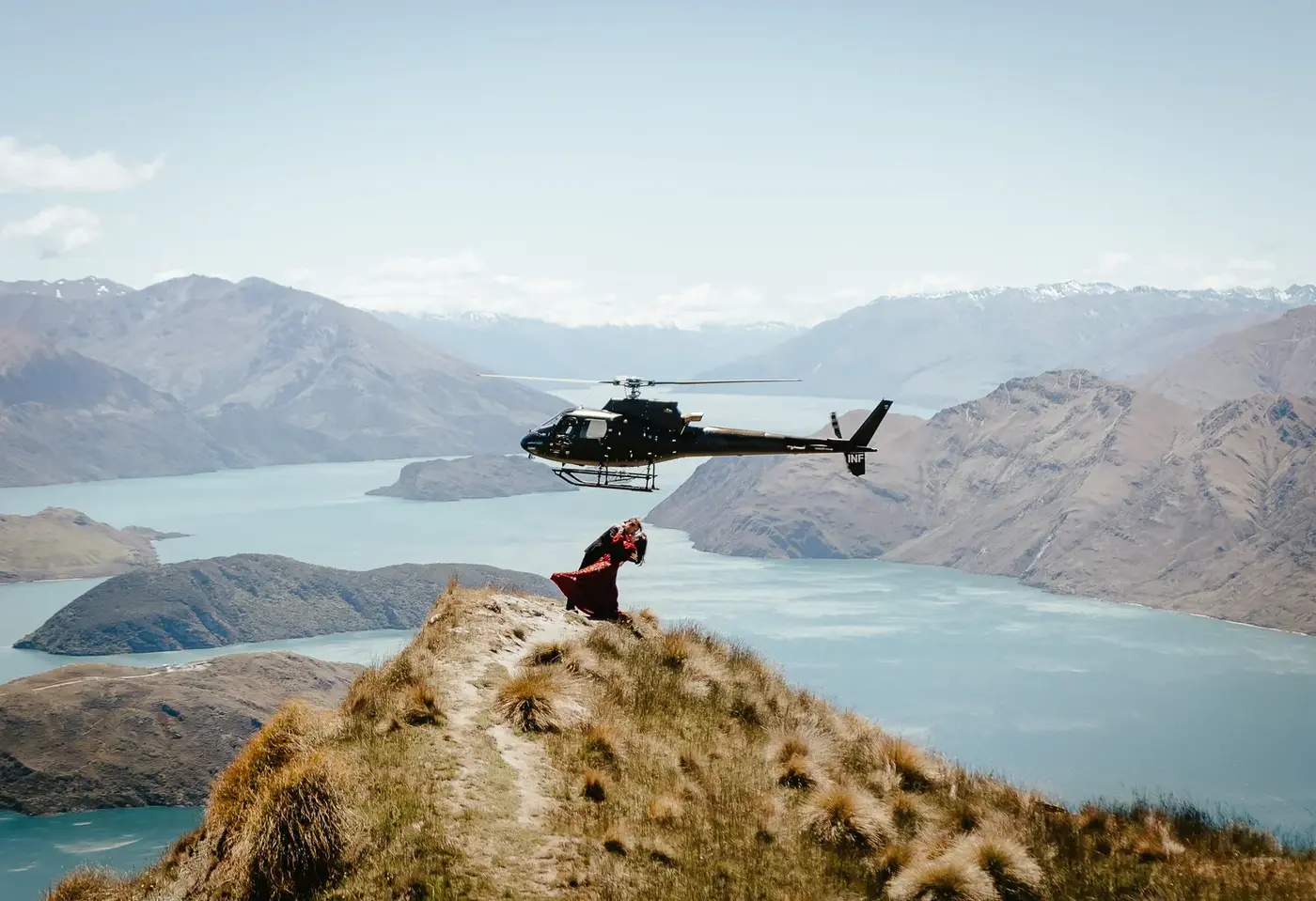 A helicopter parked on a remote alpine terrace in the mountains above Wānaka.